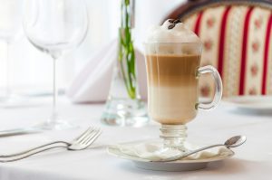 Szklanka z caffe latte na eleganckim stole